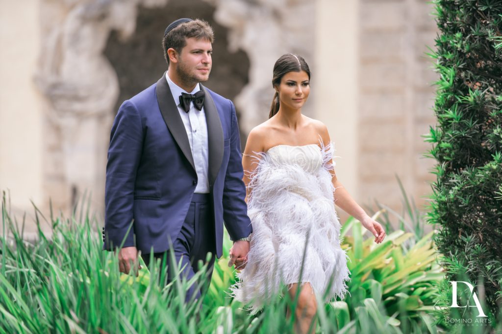 Couple walking hand in hand at Haute Couture Engagement Session at Vizcaya Museum and Gardens Miami by Domino Arts Photography