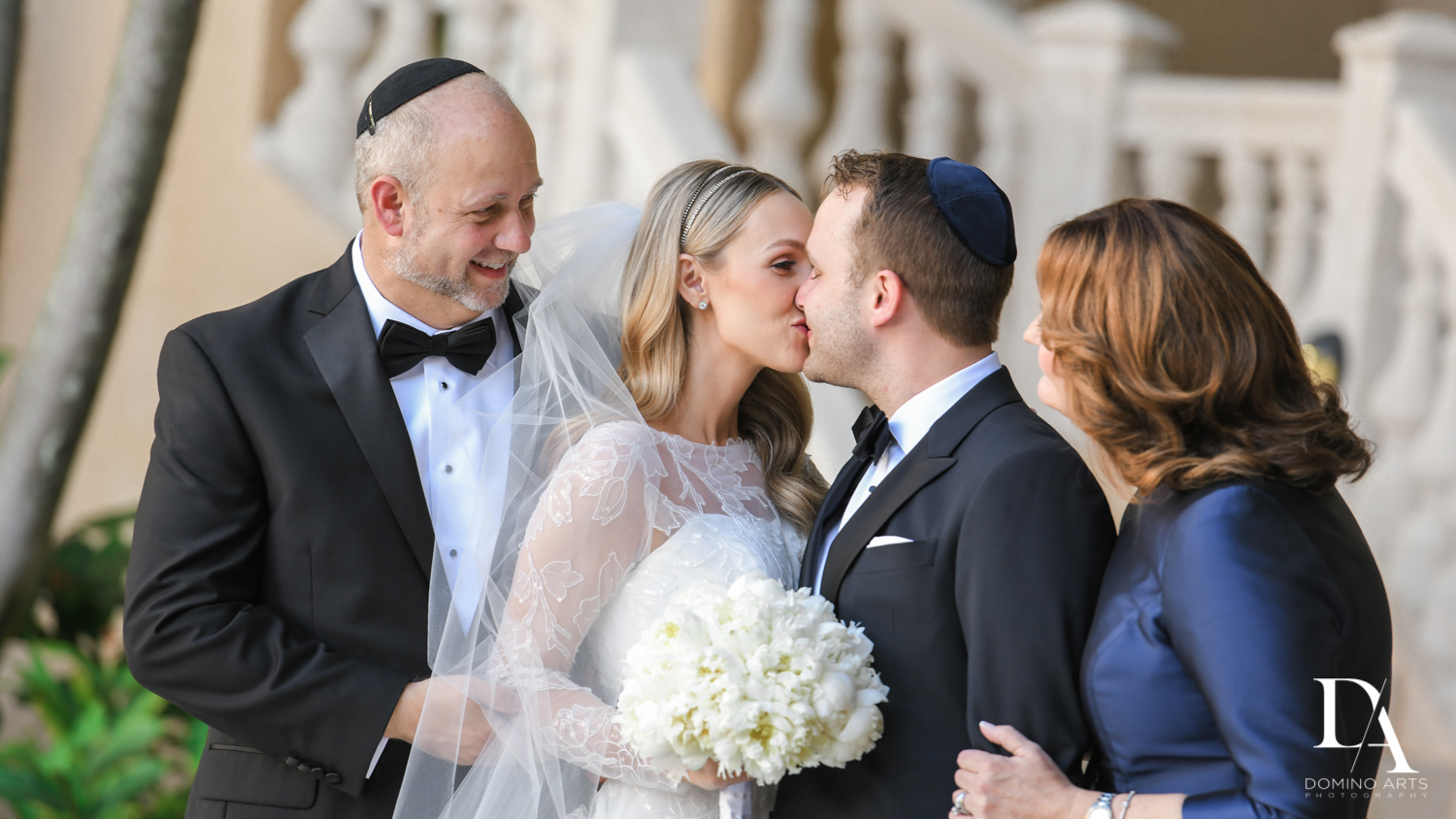wedding kiss at Lavish Flowers & Crystals Wedding at Aventura Turnberry Jewish Center by Domino Arts Photography