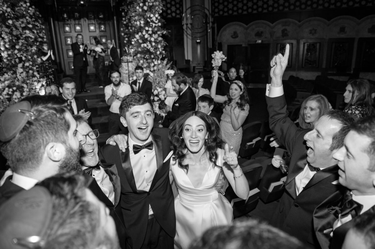 Bride and groom lifted during a Jewish wedding celebration at a Miami synagogue.